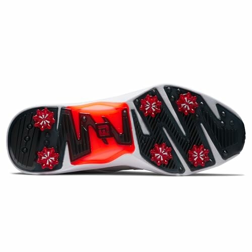 Golf shoe sole with red spikes and black tread pattern.