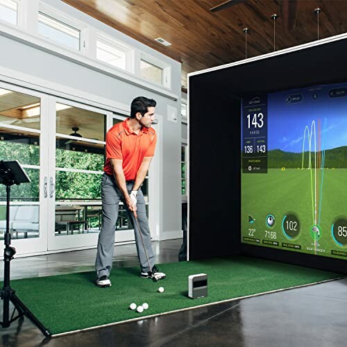 Man playing golf using an indoor simulator setup.
